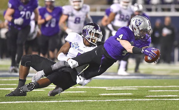 St. Thomas wide receiver Jack Gilliland (4) is tackled after his reception by Mount Union defensive back Tre Jones during the first half of the the NC