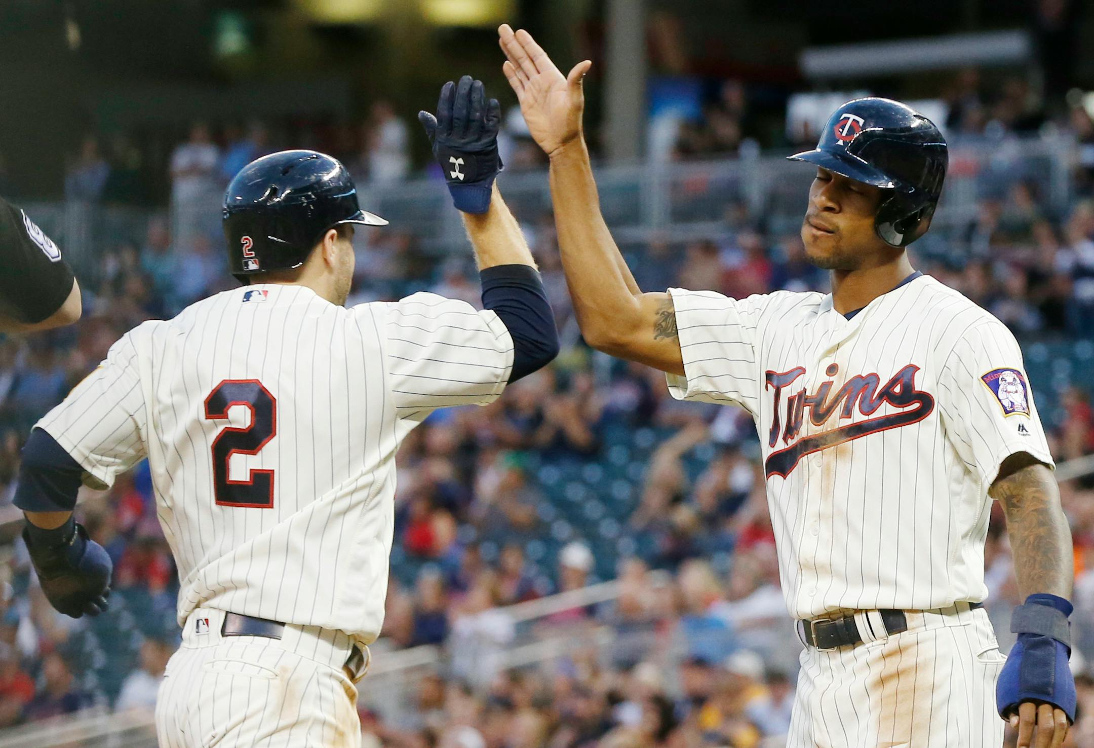 Minnesota Twins' Brian Dozier, left, and Byron Buxton celebrate as they score on a two-run ground-rule double by Jorge Polanco off Chicago White Sox pitcher Jacob Turner in the third inning of a baseball game Saturday, Sept. 3, 2016, in Minneapolis. (AP Photo/Jim Mone)