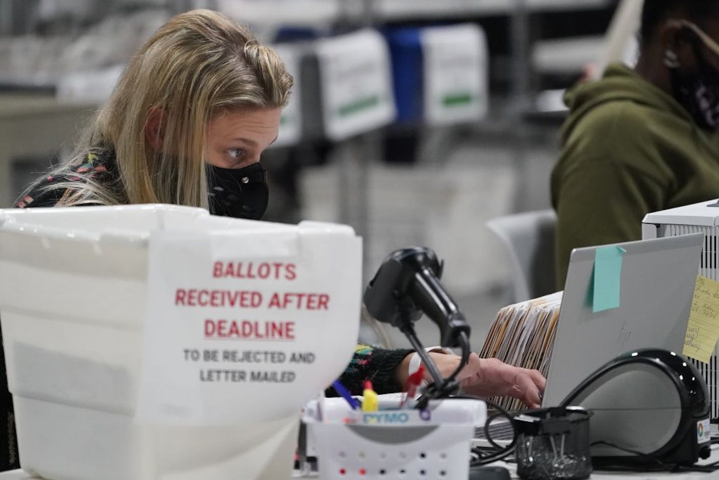 Officials work on ballots at the Gwinnett County Voter Registration and Elections Headquarters, Friday, Nov. 6, 2020, in Lawrenceville, near Atlanta.