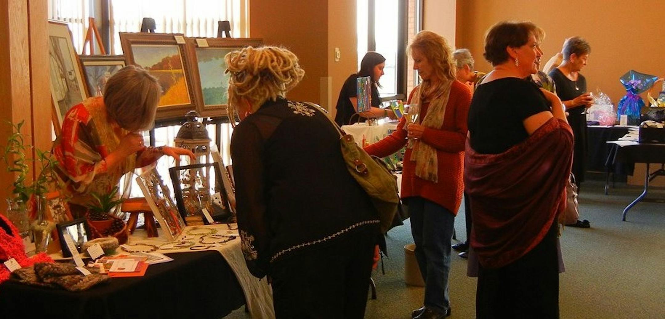 Photo courtesy of Dave Youngren Attendees at the first annual arts gala for the Hastings Prescott Area Arts Council in 2012 look at items created by member artists.