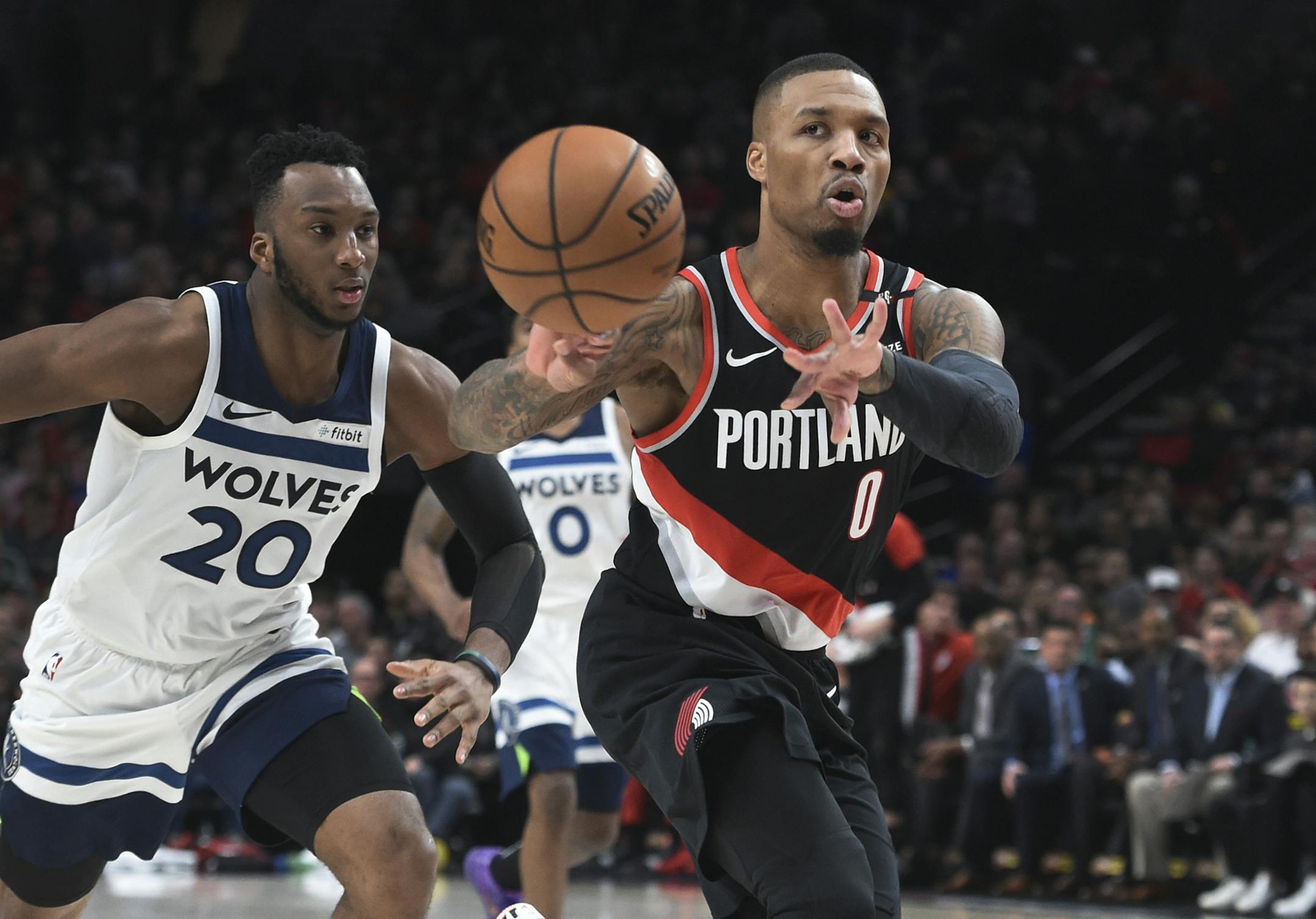 Portland Trail Blazers guard Damian Lillard, right, passes the ball away from Minnesota Timberwolves guard Josh Okogie during the second half of an NBA basketball game in Portland, Ore., Saturday, Dec. 8, 2018. The Blazers won 113-105. (AP Photo/Steve Dykes)