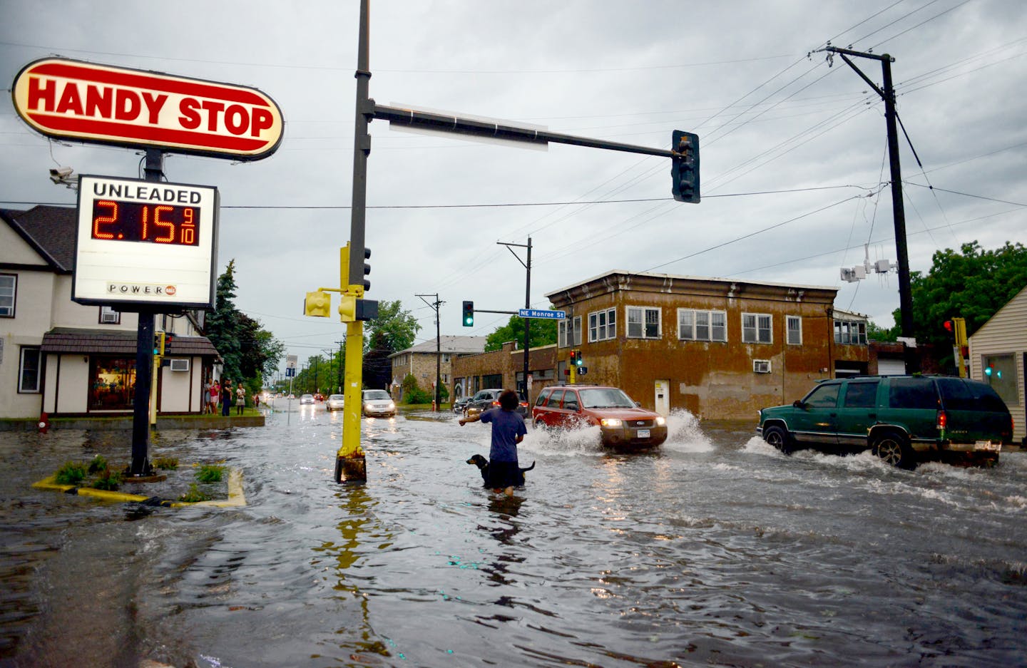 Ricky Nunn and dog Visha splashesd through the intersection near Lowry and Monroe avenues in northeast Minneapolis during the storm Tuesday evening.