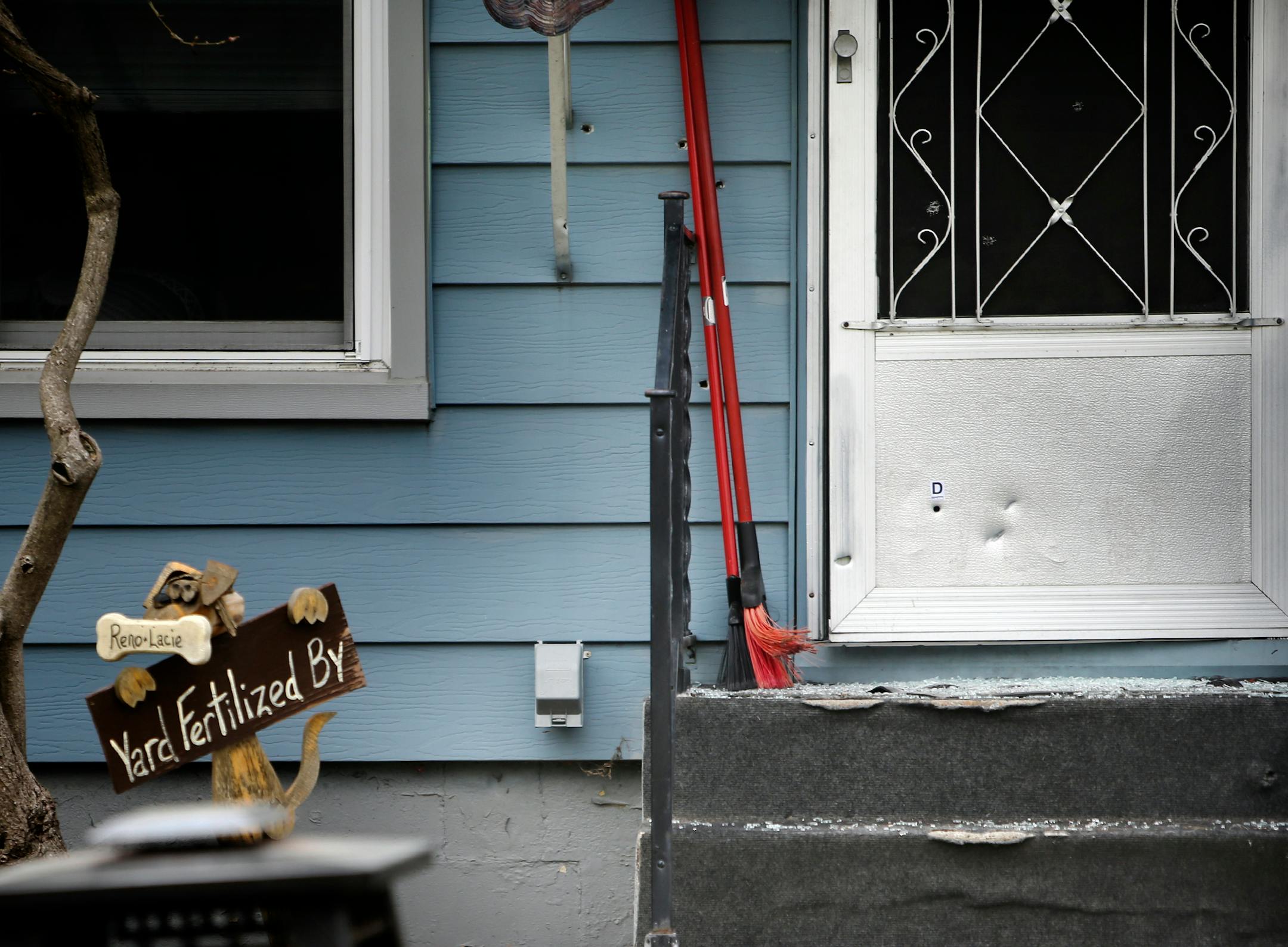 Several bullet holes are visible in the side of the victim's house as well as the door, Tuesday, May 6, in New Brighton.