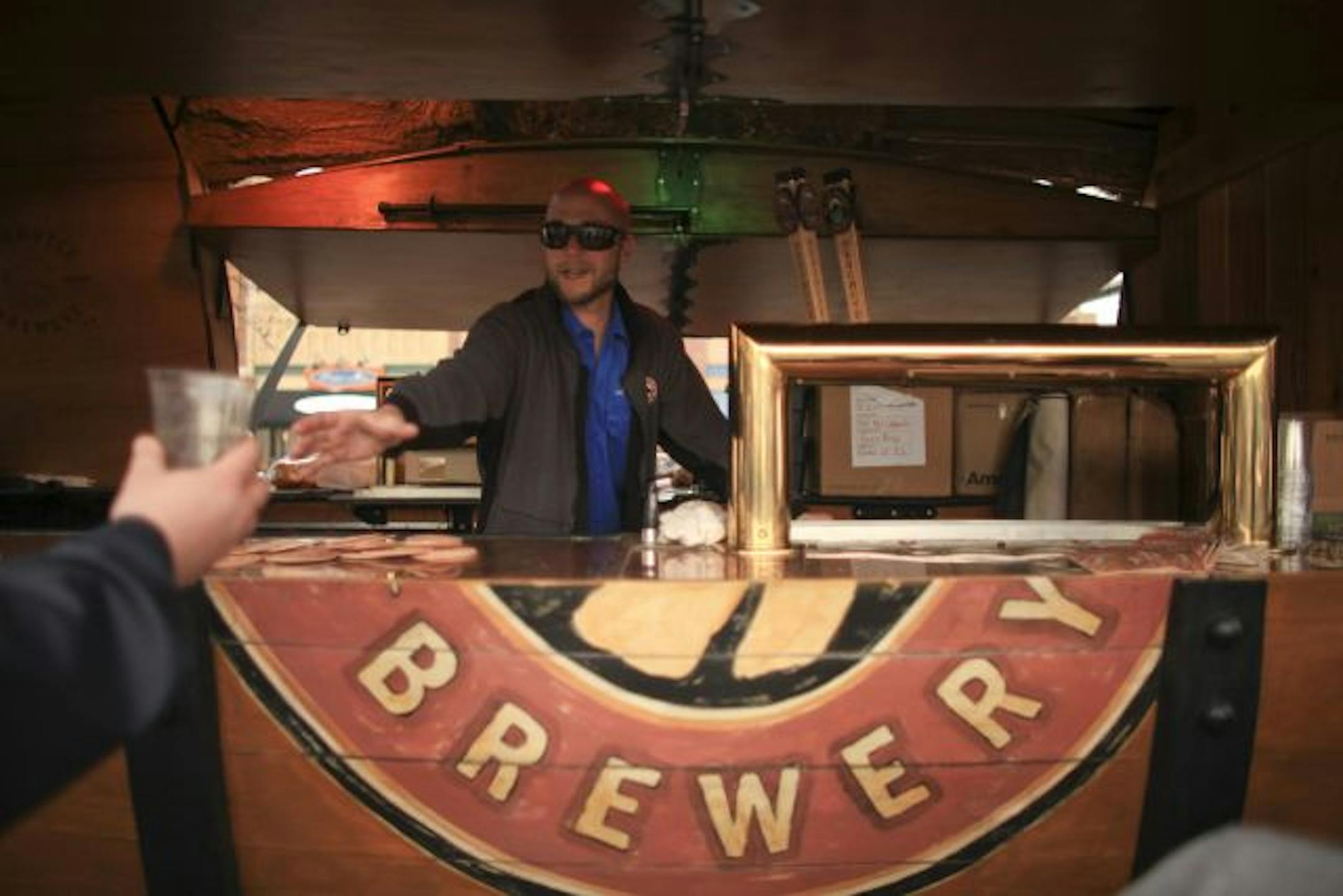 Deschutes Brewery Brand Ambassador Erik Frank reached for a patron's empty glass as he was offering samples of beer Wednesday afternoon in the parking lot of Surdyk's in Minneapolis.