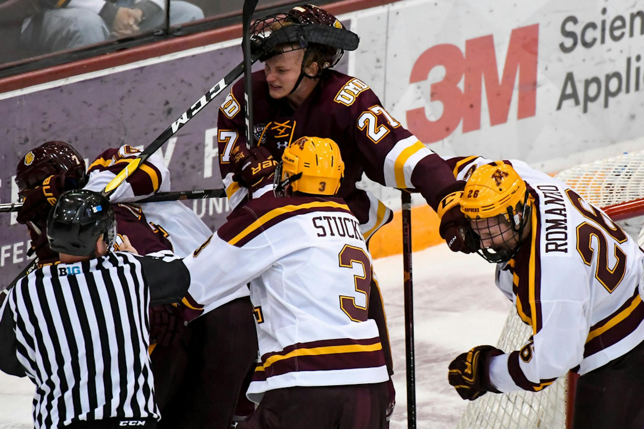 Minnesota-Duluth Bulldogs forward Riley Tufte (27) and Minnesota Golden Gophers forward Darian Romanko (26) tussled during the third period of a game last season.