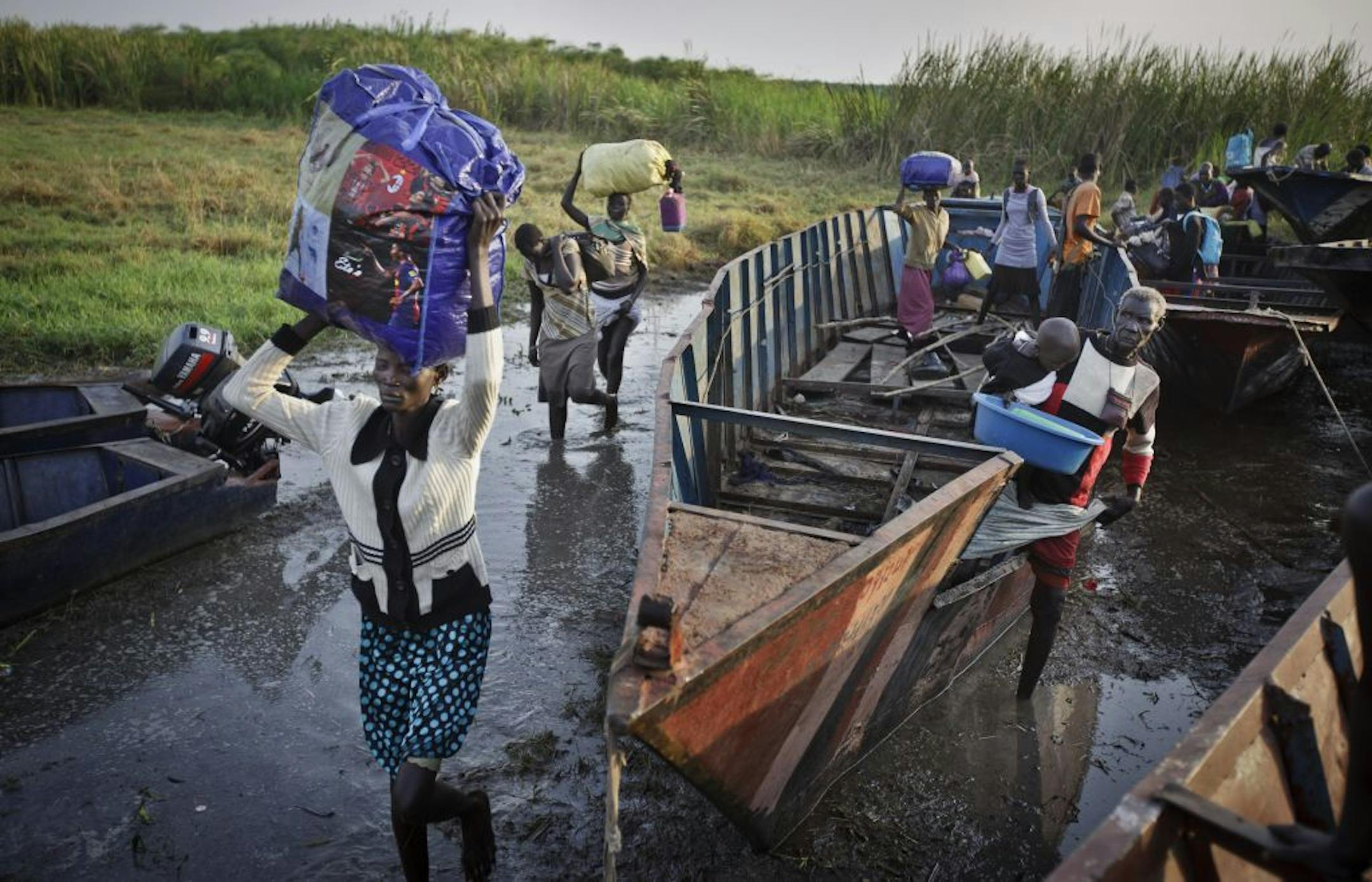 FILE - In this Thursday, Jan. 2, 2014 photo, displaced people arrive with what belongings they had time to gather by river barge from Bor, some of the thousands who fled the recent fighting between government and rebel forces in South Sudan.