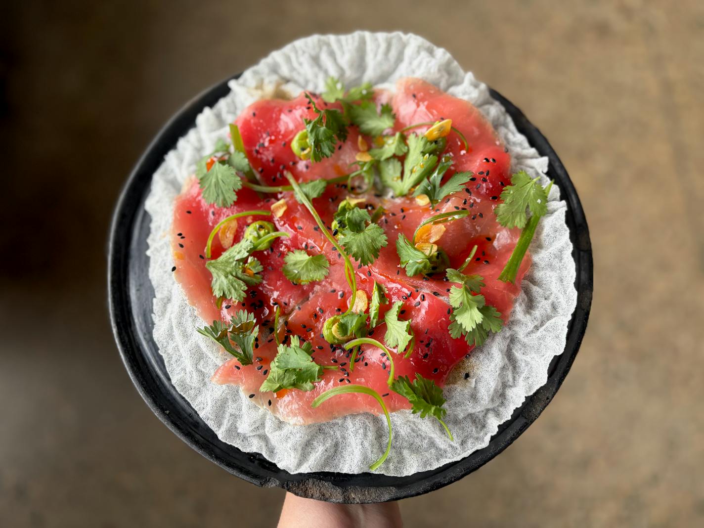 Aguachile with thin, raw ahi tuna with avocado, jalapeños, garlic chips, served on a puffed rice cracker.