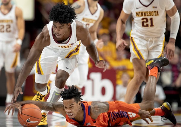 Minnesota guard Marcus Carr (5) and Clemson guard Al-Amir Dawes (2) fought for a loose ball in the first half.