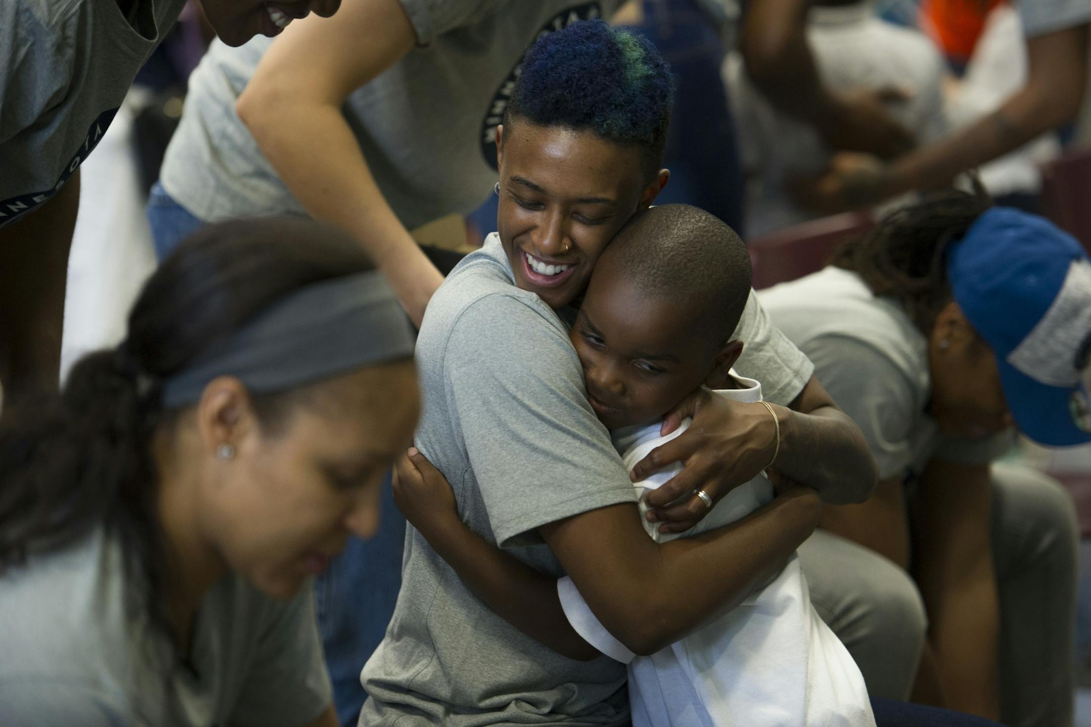WNBA Champion Minnesota Lynx guard Danielle Robinson hugs a student after washing his feet and tying on a new pair of Nike Jordan shoes at Payne Elementary School in Washington, Wednesday, June 6, 2018. Payne Elementary has the highest homeless student population in the district.