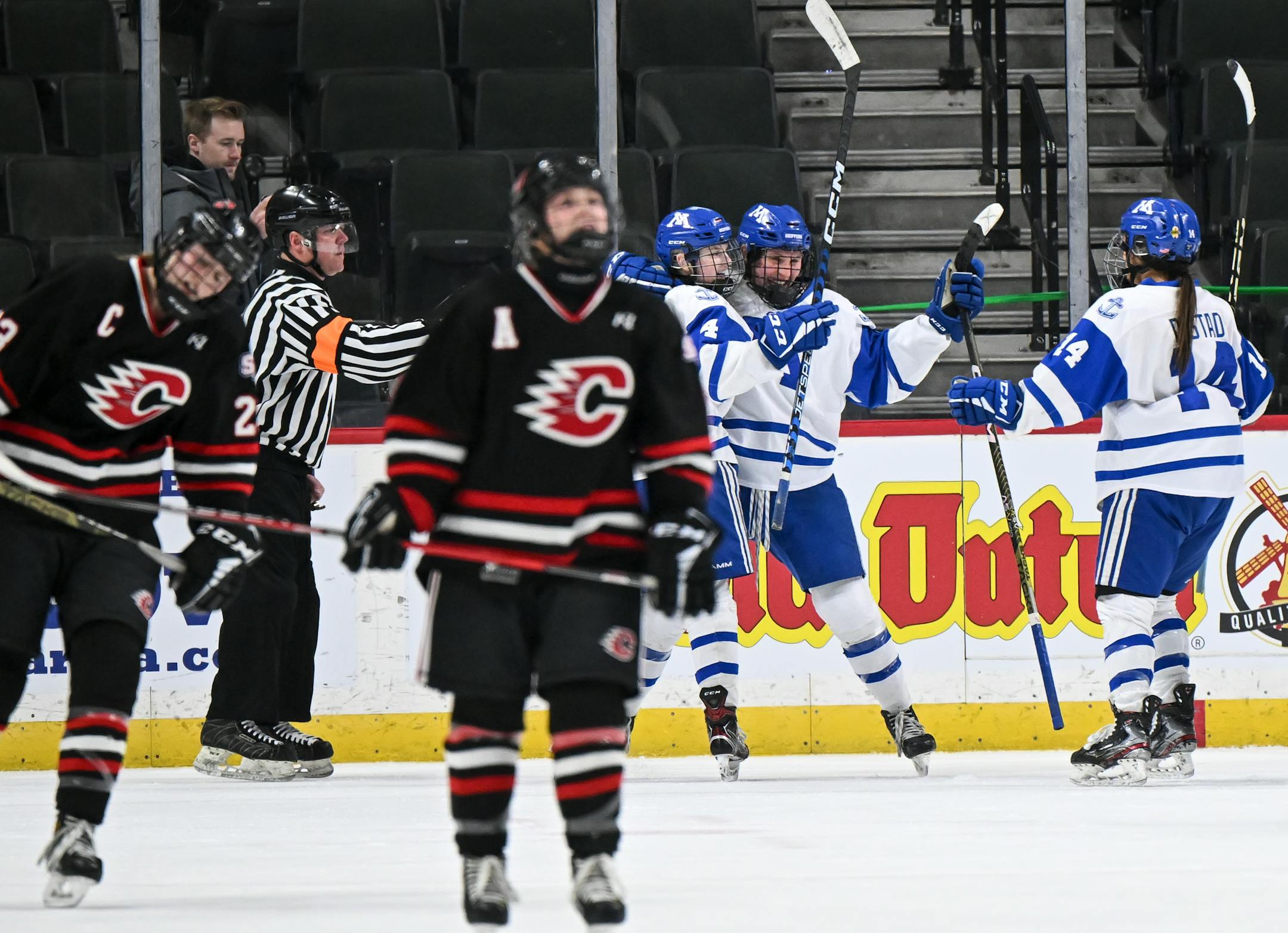 Minnetonka defenseman Lauren Goldsworthy (4) and forward Kendra Distad (14) celebrate with forward Lindzi Avar (13), back center, after Avar scored a goal against Centennial/Spring Lake Park during the second period.