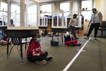 Harvest Best Academy kindergarten teacher Sarah Swanson places students at a safe social distance during reading time in her learning pod, Tuesday, Se