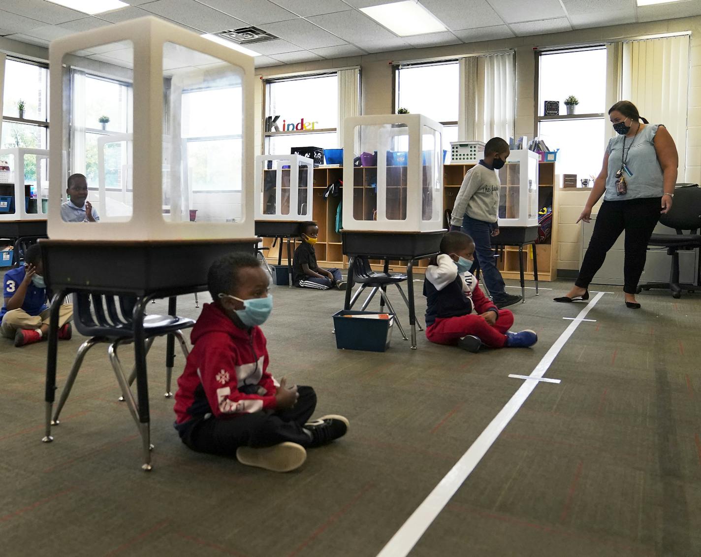 Harvest Best Academy kindergarten teacher Sarah Swanson places students at a safe social distance during reading time in her learning pod, Tuesday, Sept. 8, 2020, in Minneapolis. (David Joles/Star Tribune)