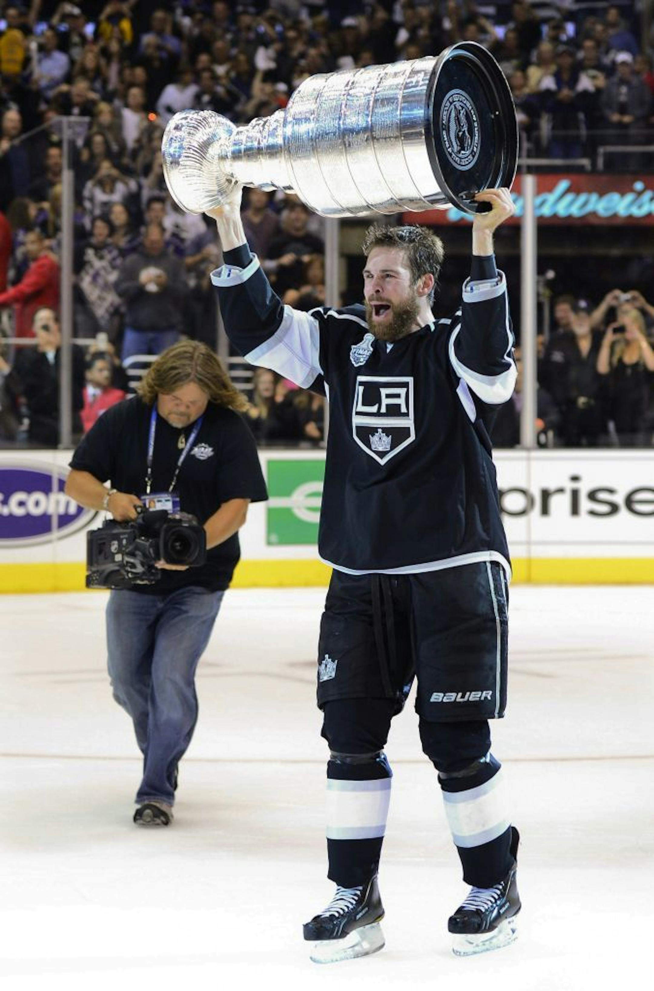 Los Angeles Kings defenseman Willie Mitchell hoists the Stanley Cup after the Kings beat the New Jersey Devils 6-1 during Game 6 of the NHL hockey Stanley Cup finals, Monday, June 11, 2012, in Los Angeles.