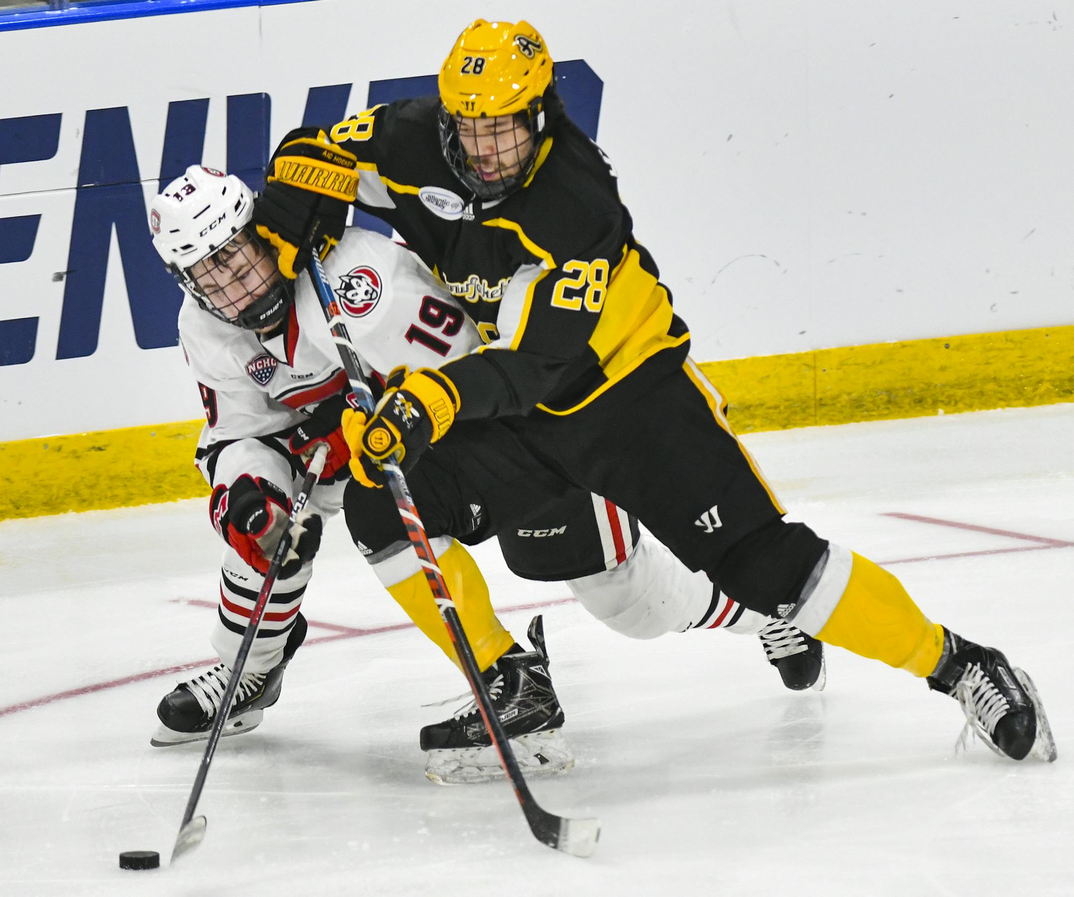 St. Cloud State's Sam Hentges and American International's Elijiah Barriga compete for the puck during the first period of an NCAA men’s Division I hockey tournament regional semifinal Friday, March 29, 2019, in Fargo, N.D. (Dave Schwarz/St. Cloud Times via AP)