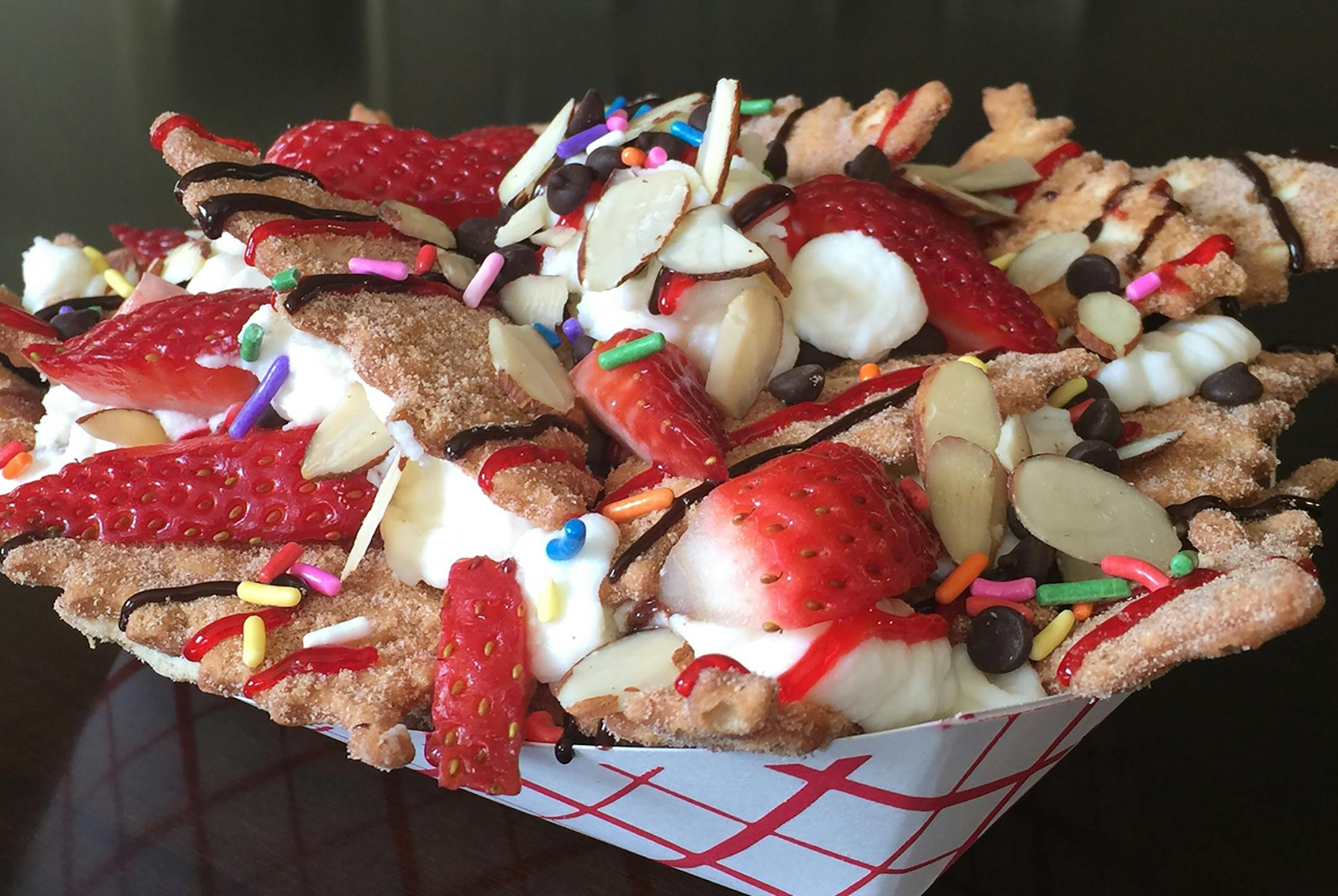 Italian Dessert Nachos: Cinnamon sugar cannoli chips smothered with sweet ricotta cheese filling, fruit, chocolate, nuts and candy toppings. Find it at Pizza Shoppe located in the Food Building, south side.