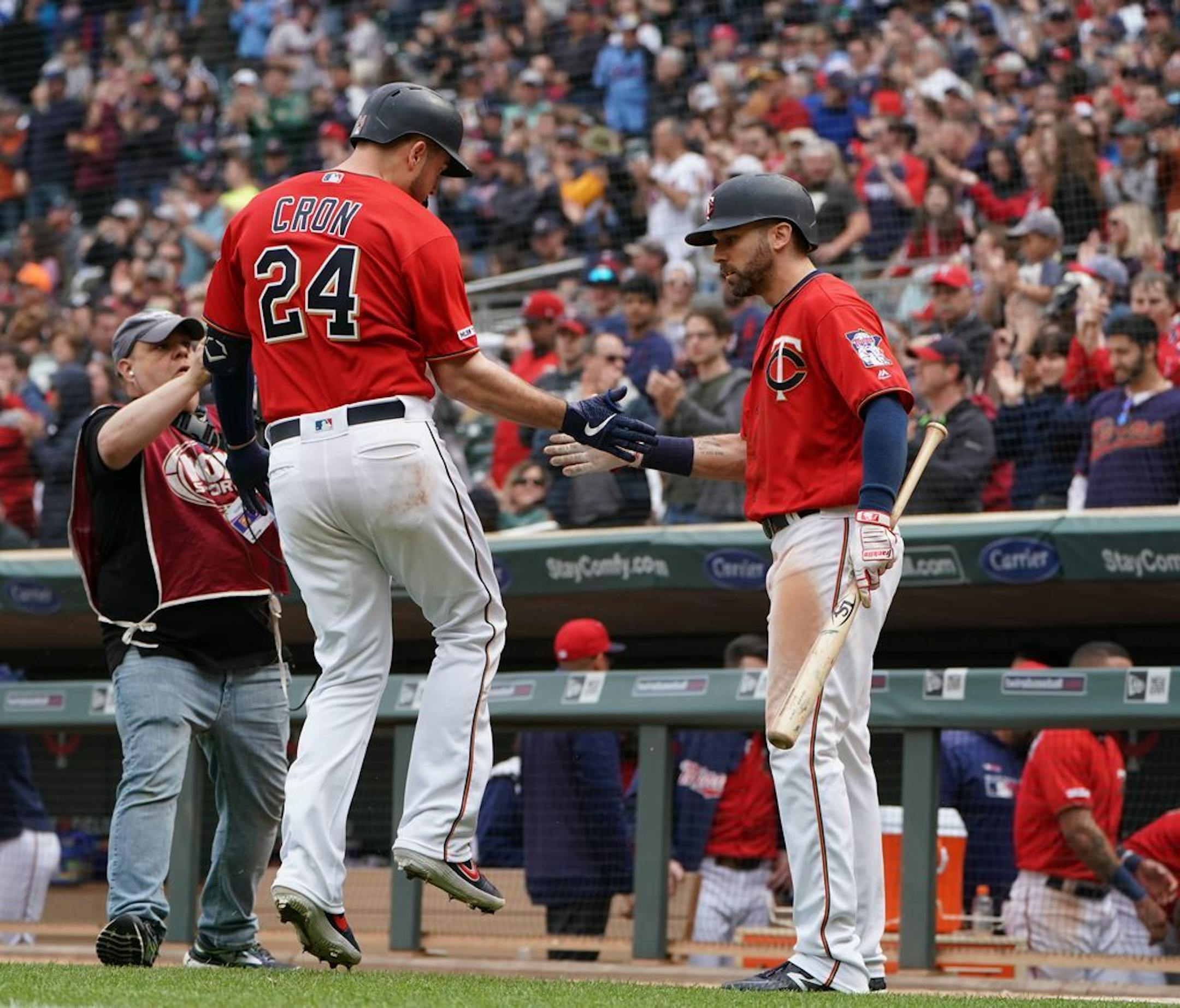Minnesota Twins first baseman C.J. Cron (24) was greeted at home plate by center fielder Jake Cave (60) after hitting a solo homerun in the eighth inning.