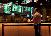 A customer makes a sports bet at in Atlantic City, N.J., just before the March Madness NCAA college basketball tournament begins in 2022,