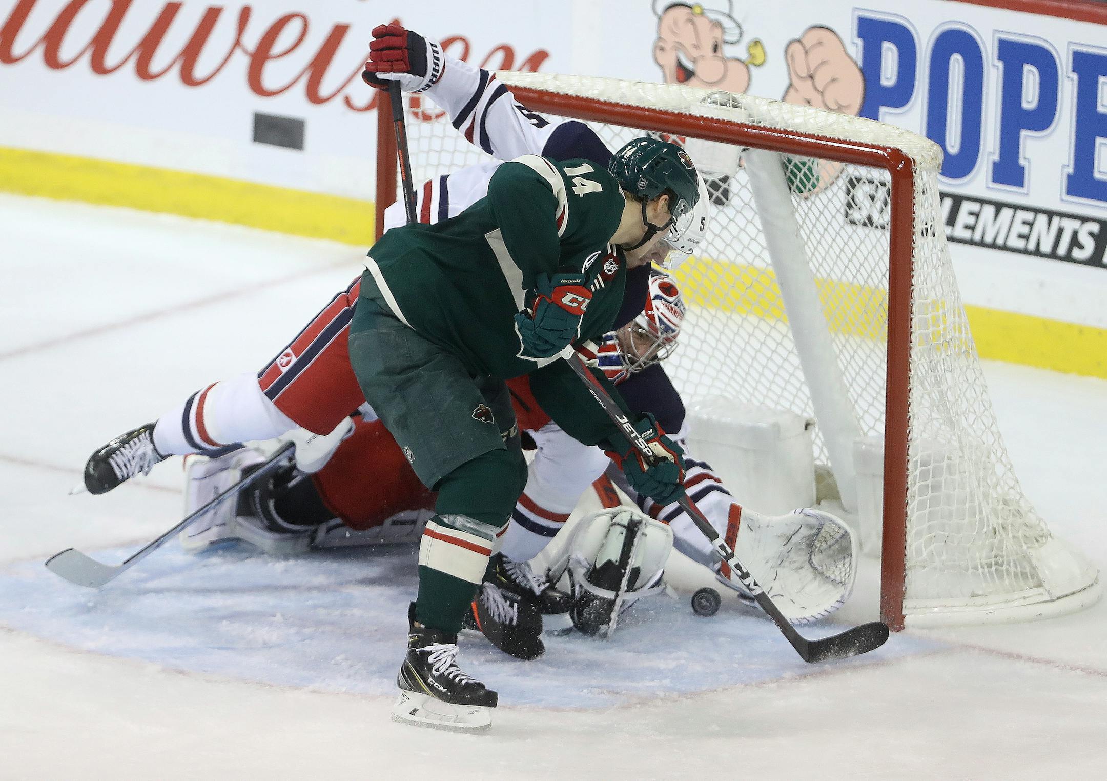 Joel Eriksson Ek bangs the puck in past the Jets' Dmitry Kulikov (5) and goaltender Connor Hellebuyck during the final minute of the third period.