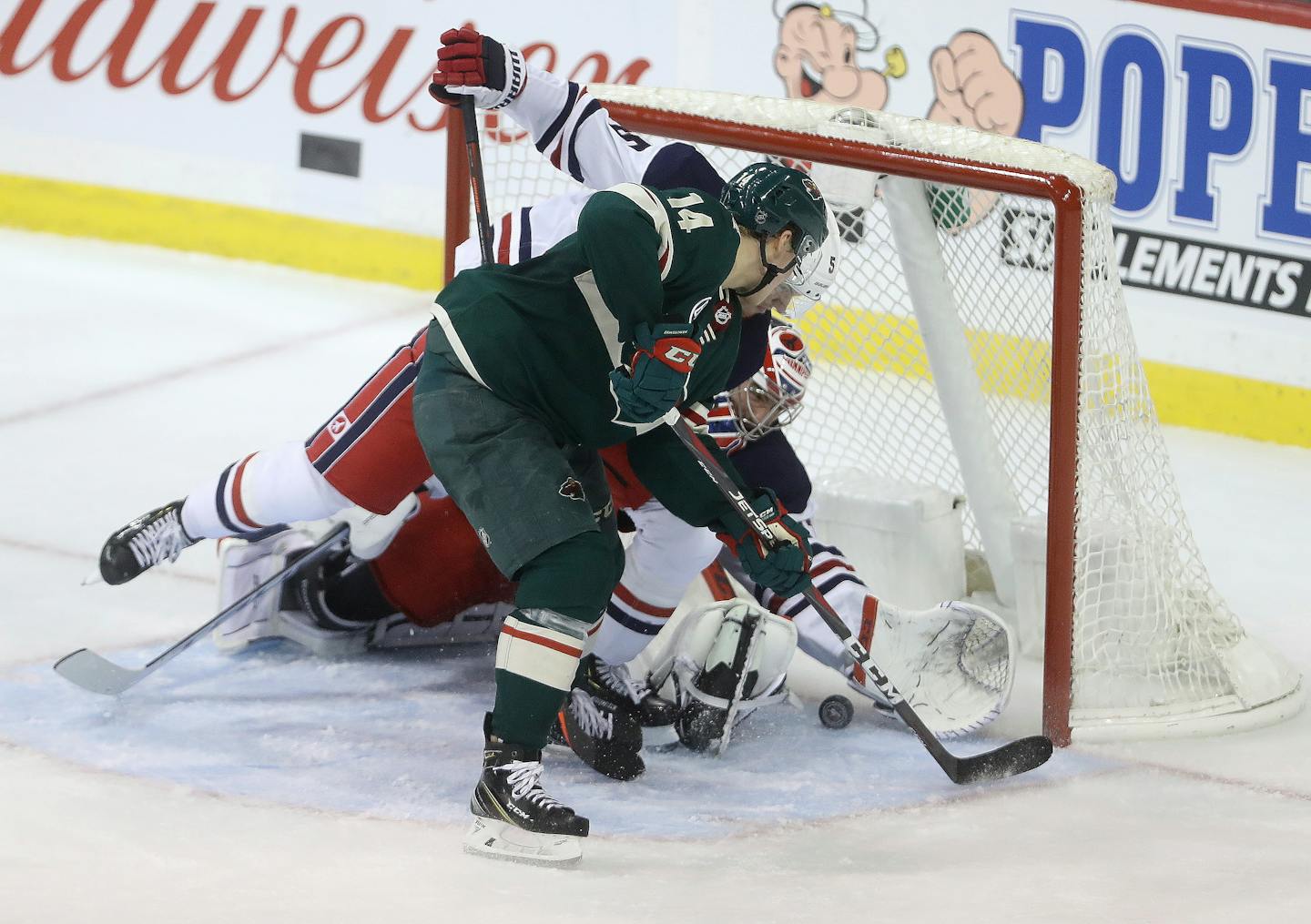 Joel Eriksson Ek bangs the puck in past the Jets' Dmitry Kulikov (5) and goaltender Connor Hellebuyck during the final minute of the third period.