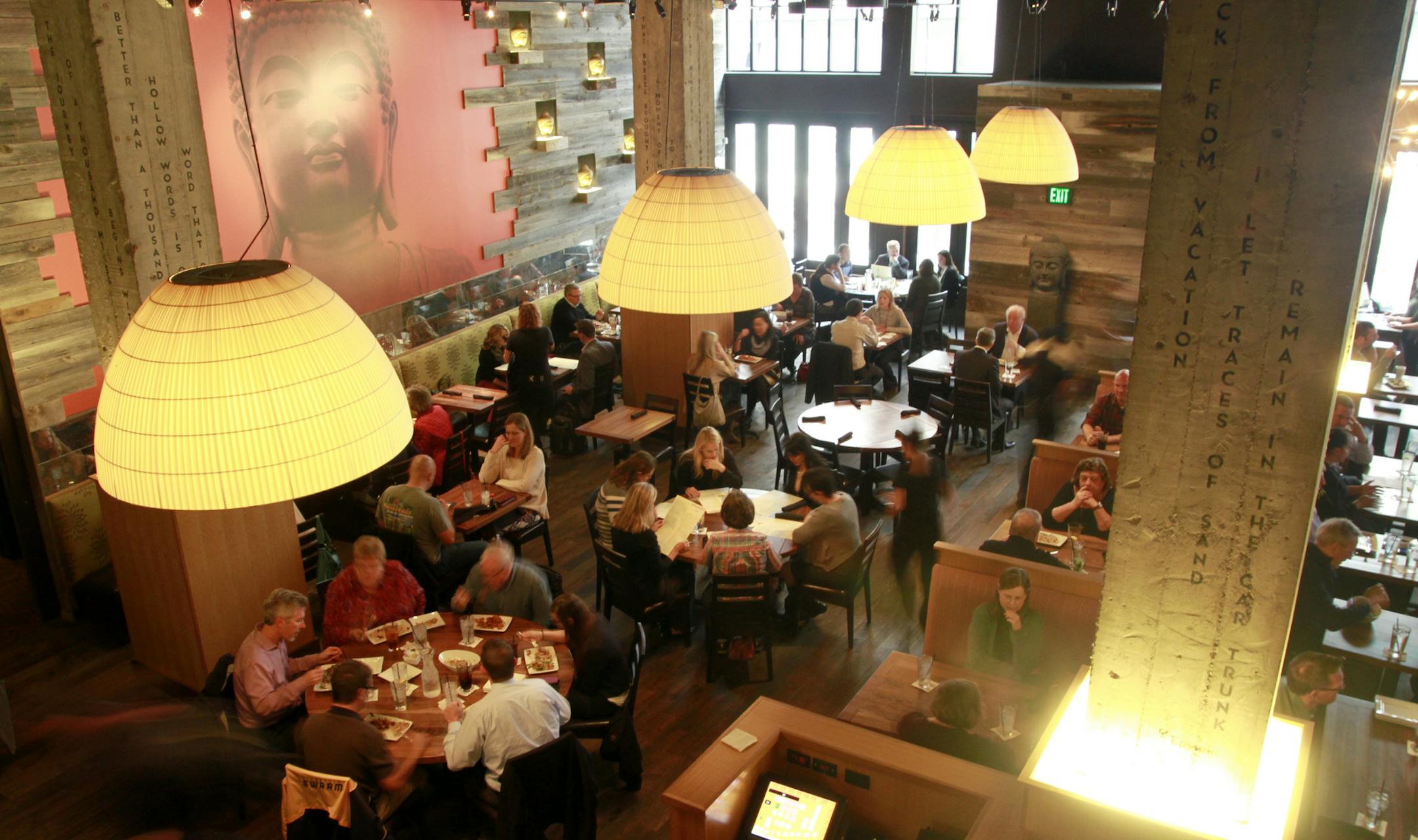 The main-floor dining room, with its wood and concrete accents, as seen from the mezzanine.