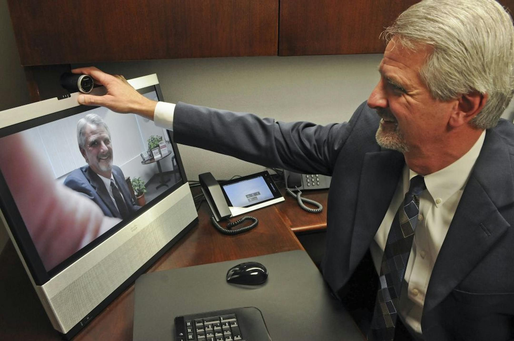 CEO John Finke adjusted the camera on HickoryTech's Telepresence videoconferencing system.