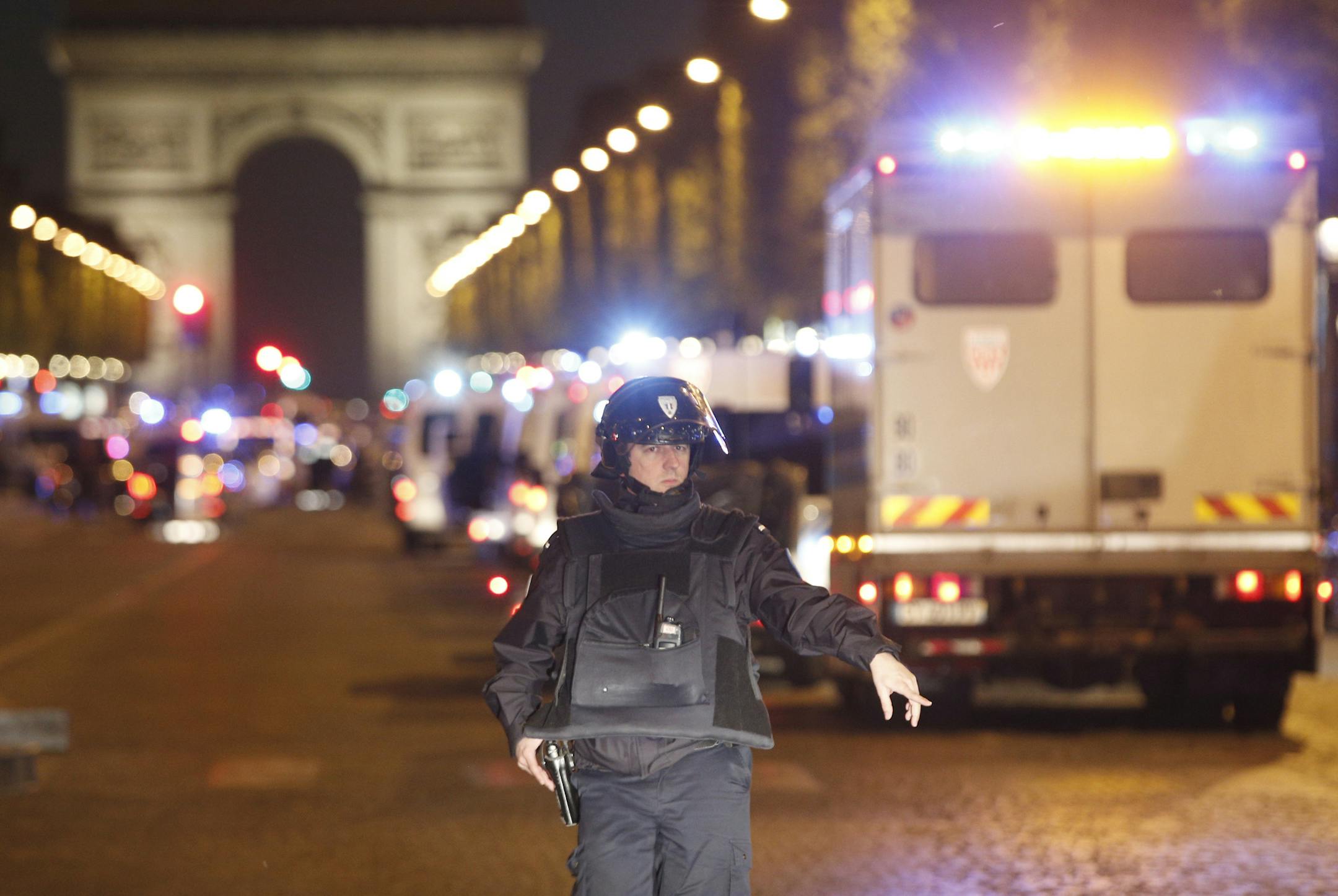 A police officer stands guard after a fatal shooting in which a police officer was killed along with an attacker on the Champs Elysees in Paris, France, Thursday, April 20, 2017. French media are reporting that two police officers were shot Thursday on the famed shopping boulevard. Many police vehicles can be seen on the avenue that passes many of the city's most iconic landmarks. (AP Photo/Thibault Camus)