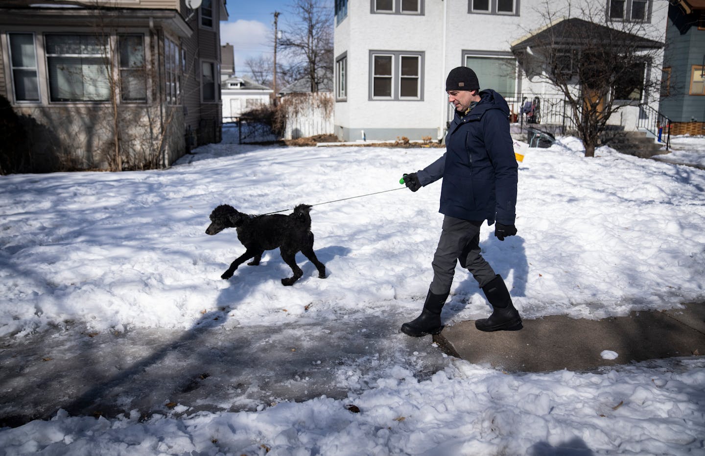 Josh Capistrant takes his dog Raven on a walk through his neighborhood on Friday, March 11, 2022 in St. Paul, Minn. Capistrant is frustrated with how several sidewalks in his neighborhood are not properly cleared of snow and ice. Even his dog will refuse to walk on ice covered sections of sidewalk, preferring to walk in the snow alongside the sidewalk. ] RENEE JONES SCHNEIDER • renee.jones@startribune.com