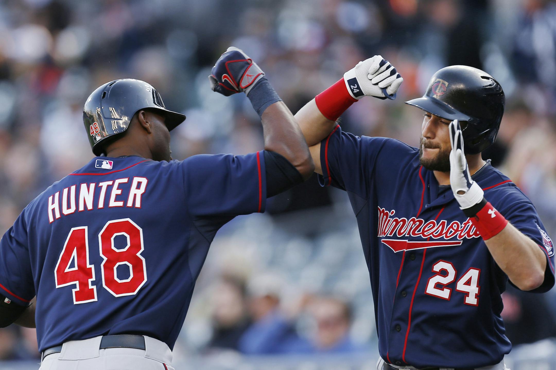 Minnesota Twins' Torii Hunter (48) celebrates his solo home run against the Detroit Tigers with Trevor Plouffe (24) during the first inning of a baseball game in Detroit on Wednesday, May 13, 2015. (AP Photo/Paul Sancya)