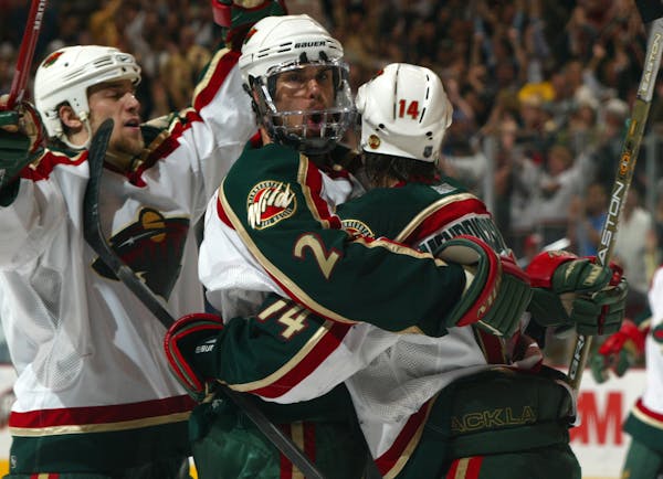 Willie Mitchell, center, celebrated a Wild goal, with teammate against Vancouver in the 2003 NHL playoffs.