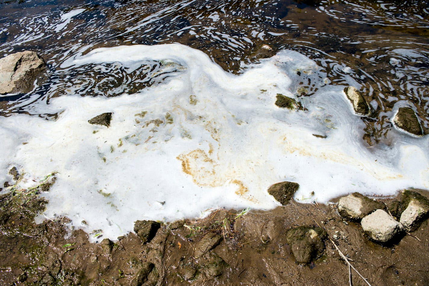 FILE - In this June 7, 2018, file photo, PFAS, or perfluoroalkyl and polyfluoroalkyl substances, foam gathers at the the Van Etten Creek dam in Oscoda Township, Mich., near Wurtsmith Air Force Base. The U.S. Department of Defense has dragged its feet on protecting service personnel from "forever chemicals" at military installations and isn't doing enough to track health effects from exposure to the toxic compounds, according to an internal audit. Officials have taken steps to find and clean groundwater contaminated with firefighting foam containing PFAS the department's inspector general found. But its recently released report said the Pentagon has fallen short on dealing with other sources of the chemicals as its rules require. (Jake May/The Flint Journal via AP, File)