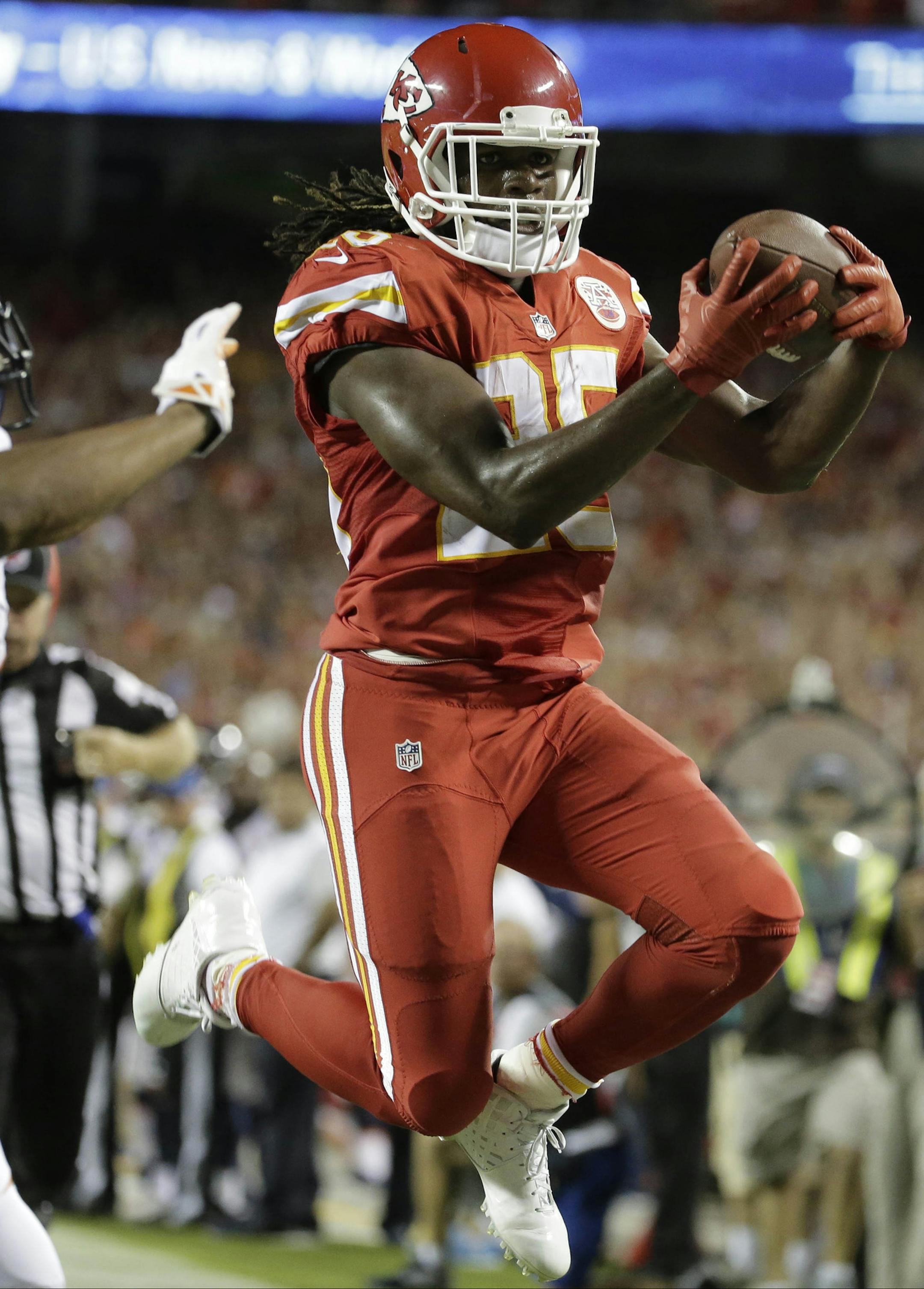 Kansas City Chiefs running back Jamaal Charles (25) scores a touchdown against Denver Broncos cornerback Chris Harris Jr. during the first half of an NFL football game in Kansas City, Mo., Thursday, Sept. 17, 2015. (AP Photo/Charlie Riedel)