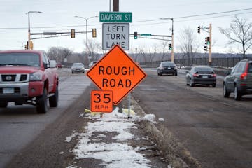 Shepard Road in St. Paul was reduced from 50 to 35 MPH because of all the potholes, cars are seen driving on Shepard Road near Davern Street on Friday