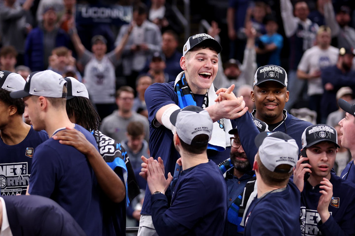 Connecticut's Donovan Clingan, top middle, celebrates with teammates after a 77-52 win against Illinois on Saturday in Boston.