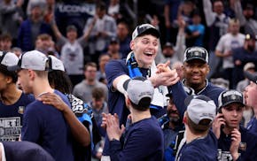 Connecticut's Donovan Clingan, top middle, celebrates with teammates after a 77-52 win against Illinois on Saturday in Boston.