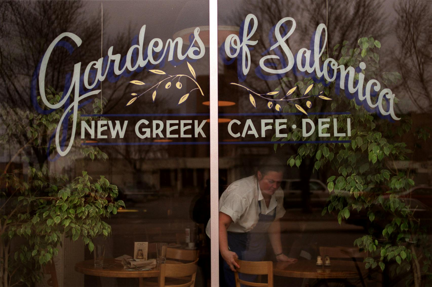 Taste East Hennepin Neighborhood story on the eating establishments. — Anna Christoforides cleans up the tables in the window at The Garden Of Salonica New Greek Cafe and Deli on the North East side.