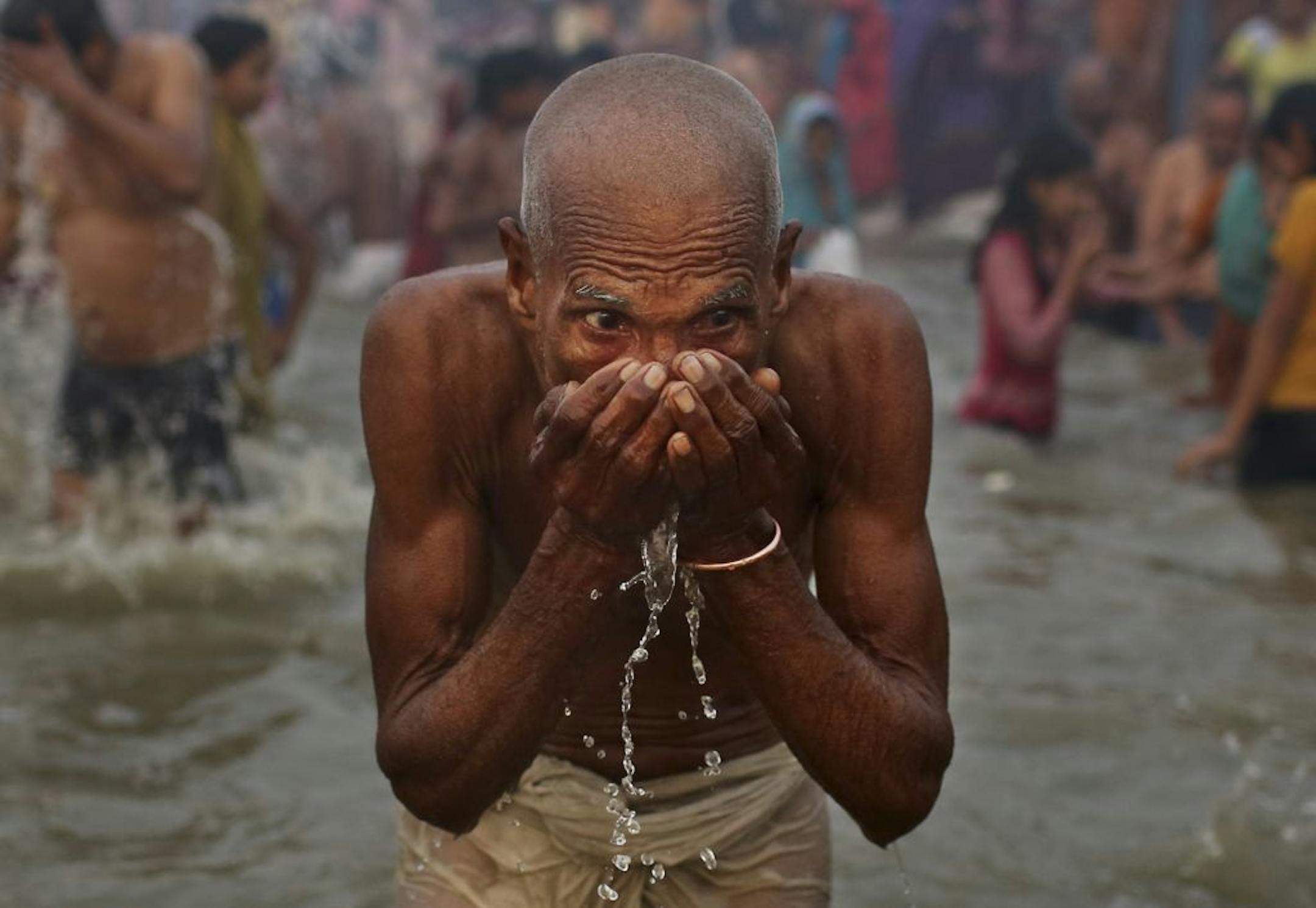 An Indian Hindu drinks water as he prays at Sangam, the confluence of the rivers Ganges, Yamuna and mythical Saraswati, during the royal bath on Makar Sankranti at the start of the Maha Kumbh Mela in Allahabad, India, Monday, Jan. 14, 2013. Millions of Hindu pilgrims are expected to take part in the large religious congregation that lasts more than 50 days on the banks of Sangam during the Maha Kumbh Mela in January 2013, which falls every 12th year.