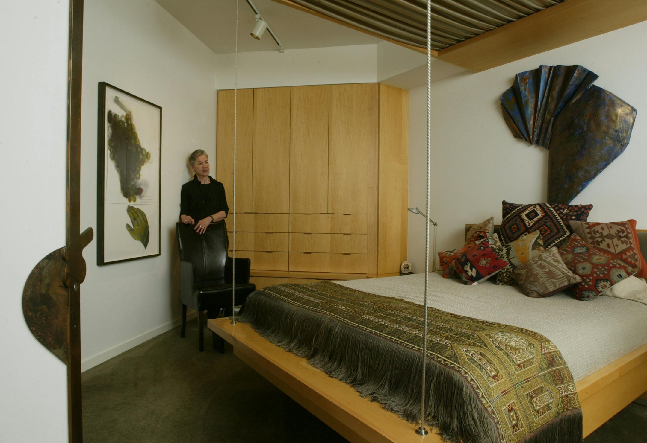 "Everything here has a story," said artist Harriet Bart of her condo. The sculptural door hardware, left, was created by local furniture designer Thomas Oliphant; the "floating" bed was designed by his wife, interior designer Lynn Barnhouse; and the painting and sculpture are the work of local artist Vesna Kittelson.
