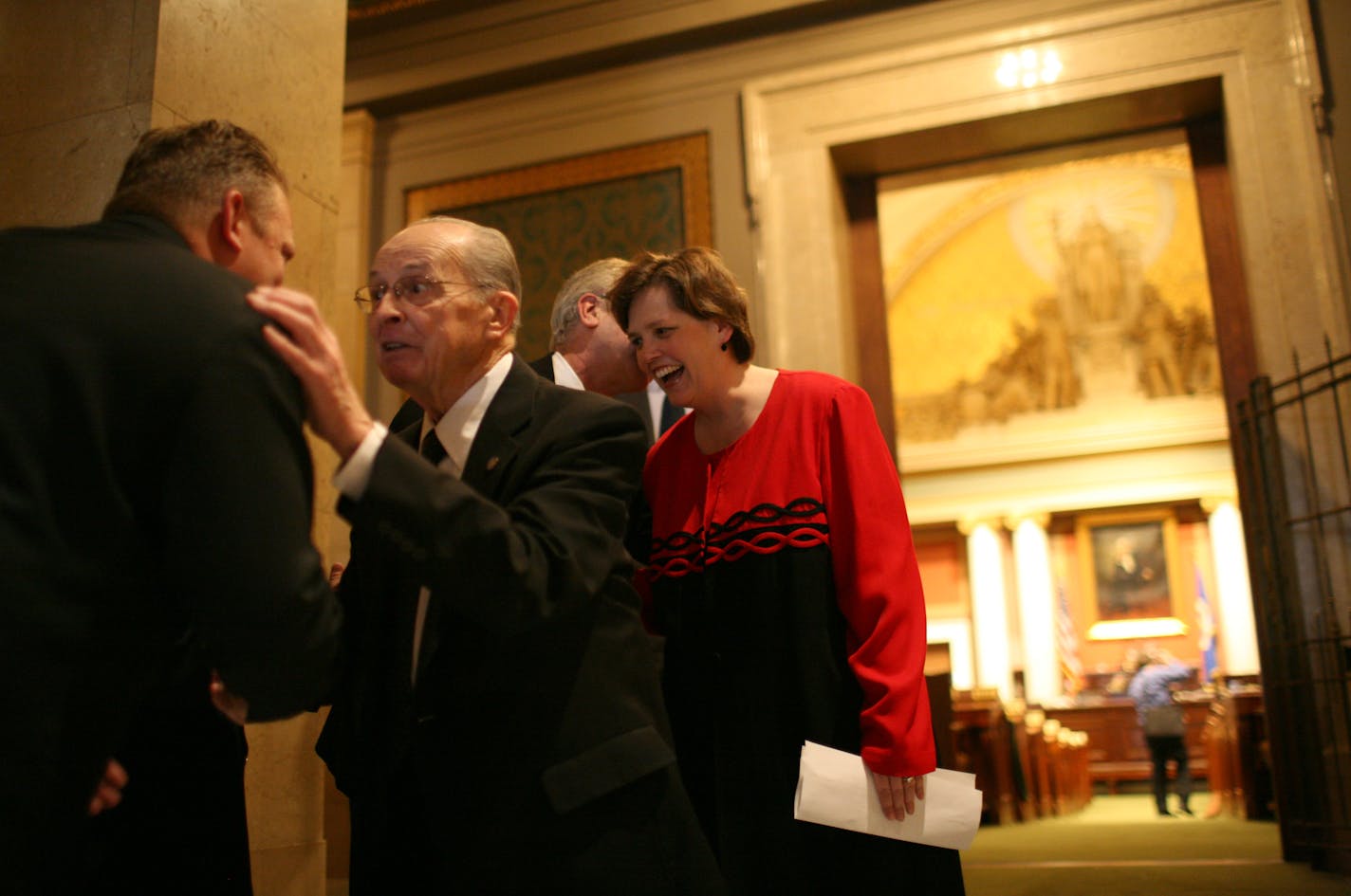 Rep. Bernie Lieder, DFL-Crookston, at left facing the camera, and Speaker Margaret Anderson Kelliher, DFL-Minneapolis, were congratulated after the House vote Monday.