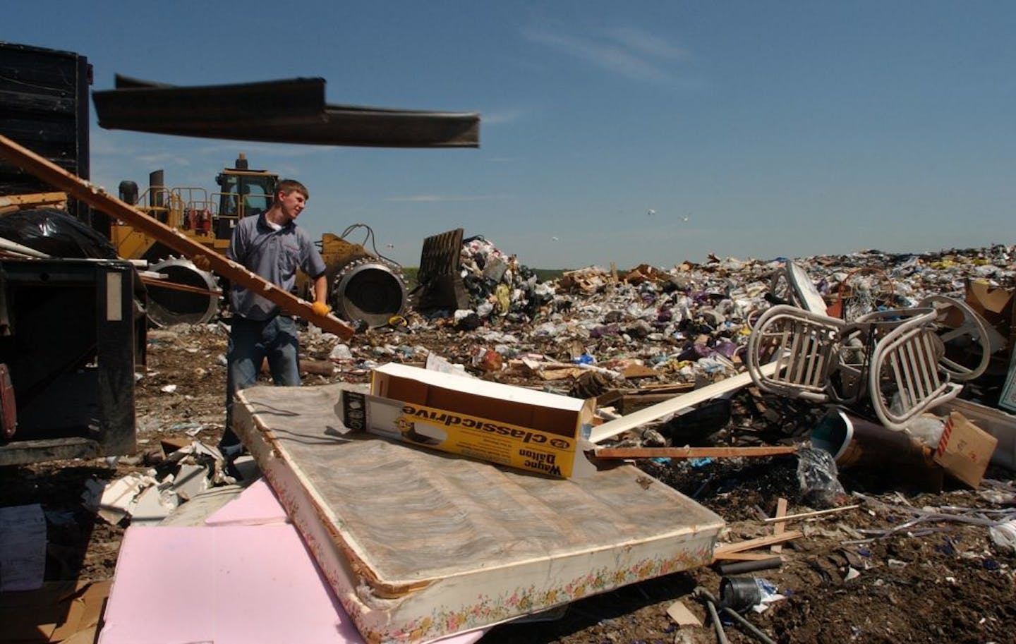 Joey McLeister/Star Tribune Burnsville,Mn.,Thurs.,July 8, 2004--Eric Olson, one of the Junk Squad employees, helps unload the last pieces of junk from the truck at the Burnsville Sanitary Landfill. The load cost $200 to dump at the landfill--mattresses are $30 apiece to dump. GENERAL INFORMATION: The Junk Squad makes house calls to solve junk problems for homes and businesses