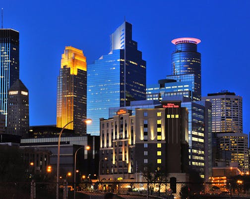 The Minneapolis skyline glimmers beneath a royal blue sky.