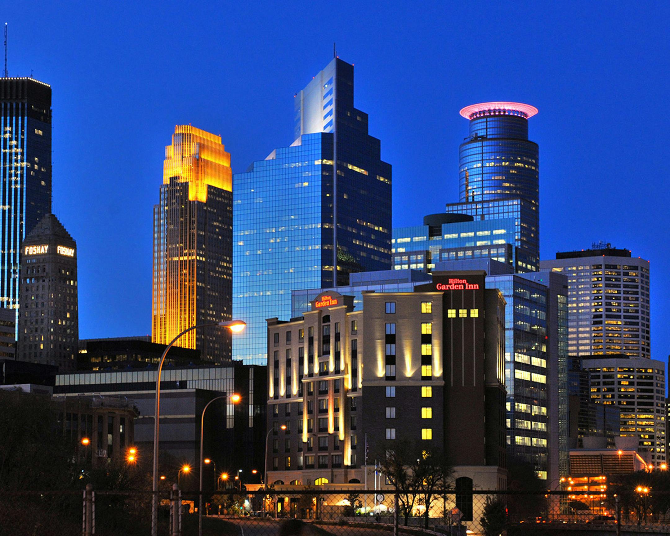 The Minneapolis skyline glimmers beneath a royal blue sky.