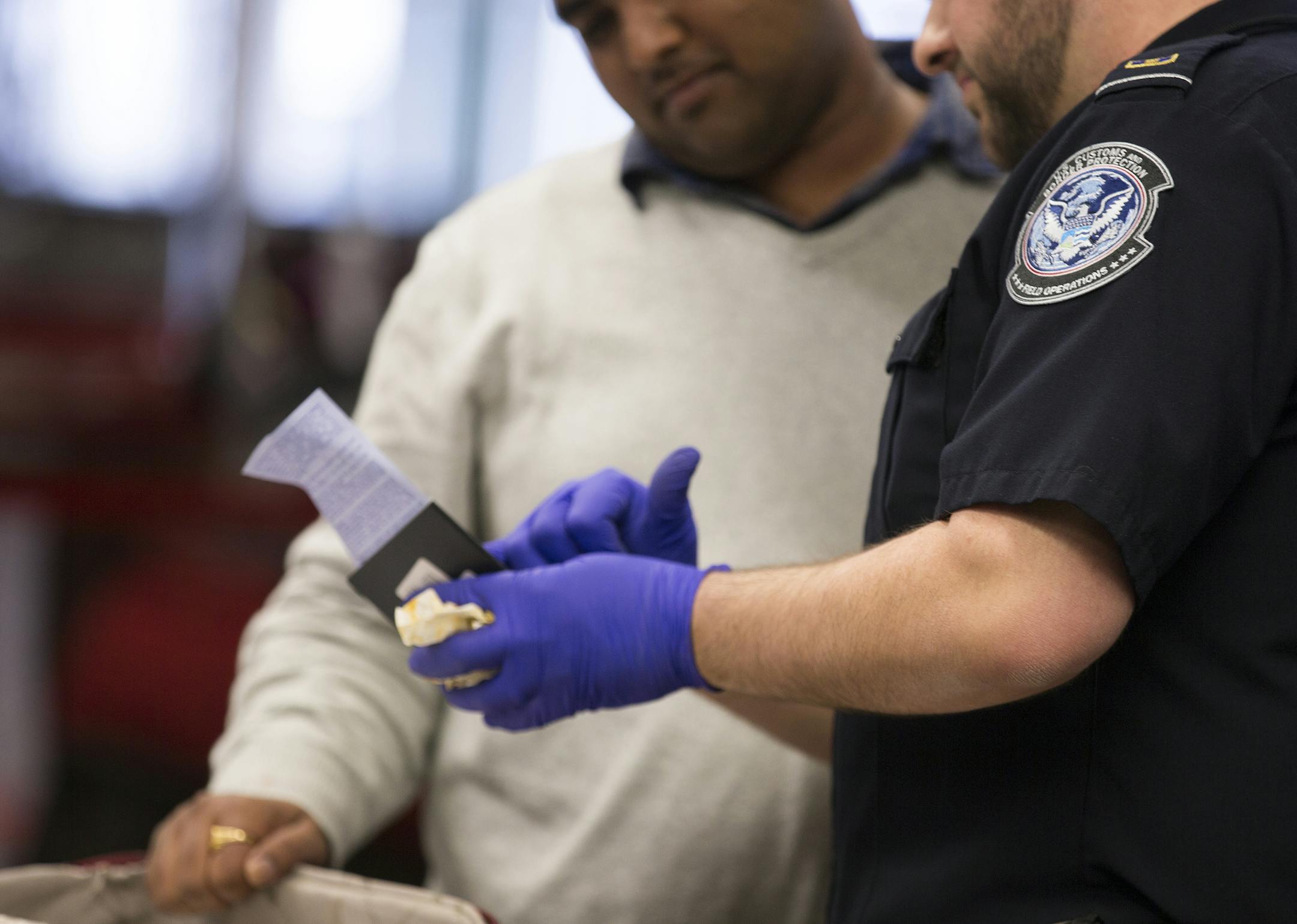 An agriculture specialist customs officer checks luggage in international arrivals at Minneapolis - St. Paul International Airport on Wednesday, March 18, 2015. ] LEILA NAVIDI leila.navidi@startribune.com /