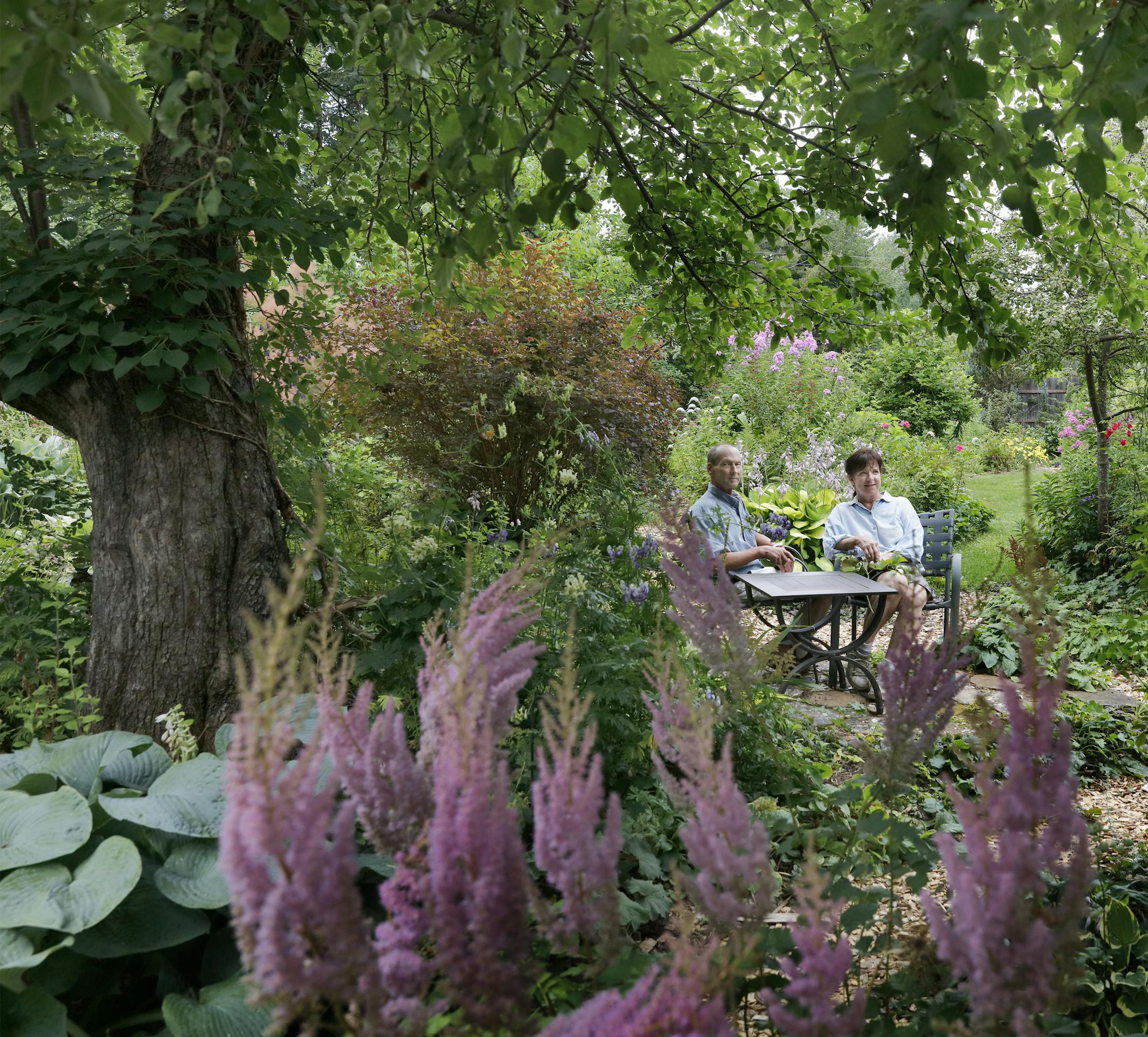 Ellen Akins and Steven Denker relax in their garden in Cornucopia, Wis.
