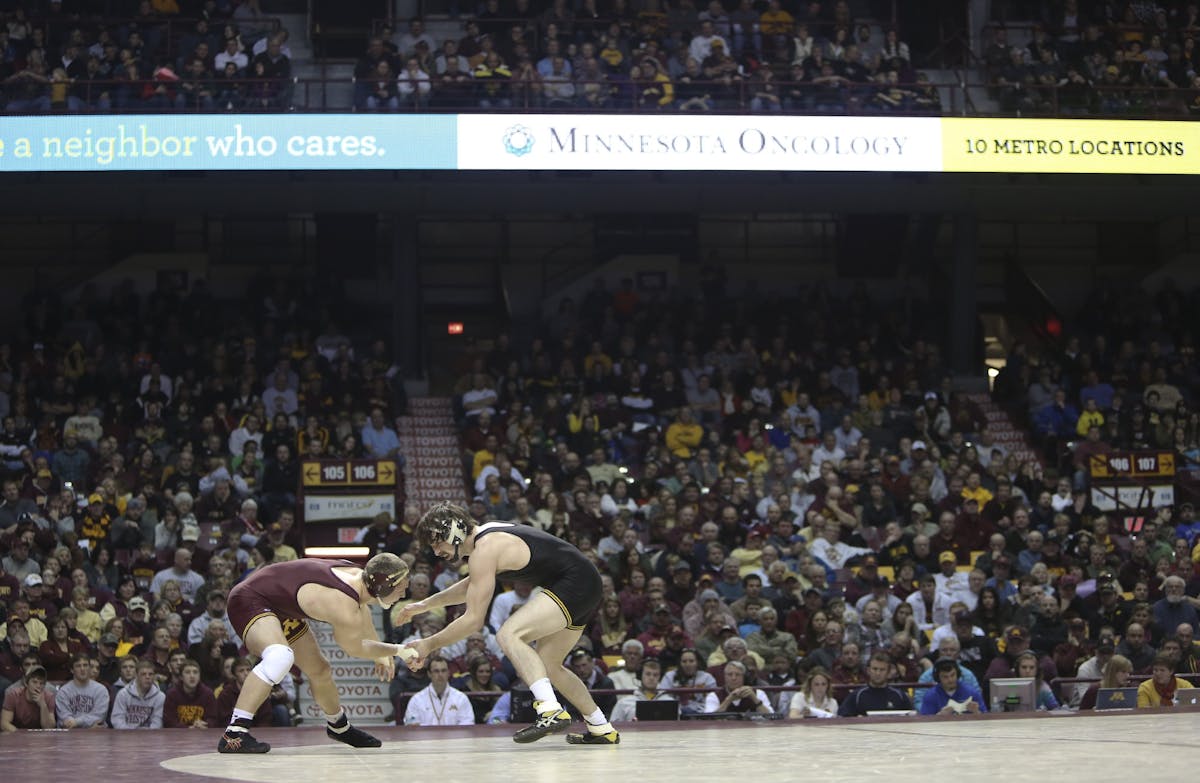 Logan Storley fought for control with Iowa's Mike Evans as they wrestled in the 174 pound weight class at Williams Arena in January