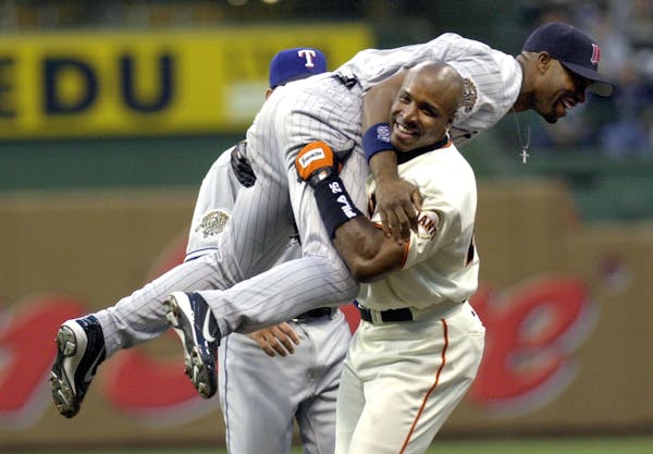 National League All-Star Barry Bonds of the San Francisco Giants playfully picks up American League All-Star Torii Hunter of the Minnesota Twins after