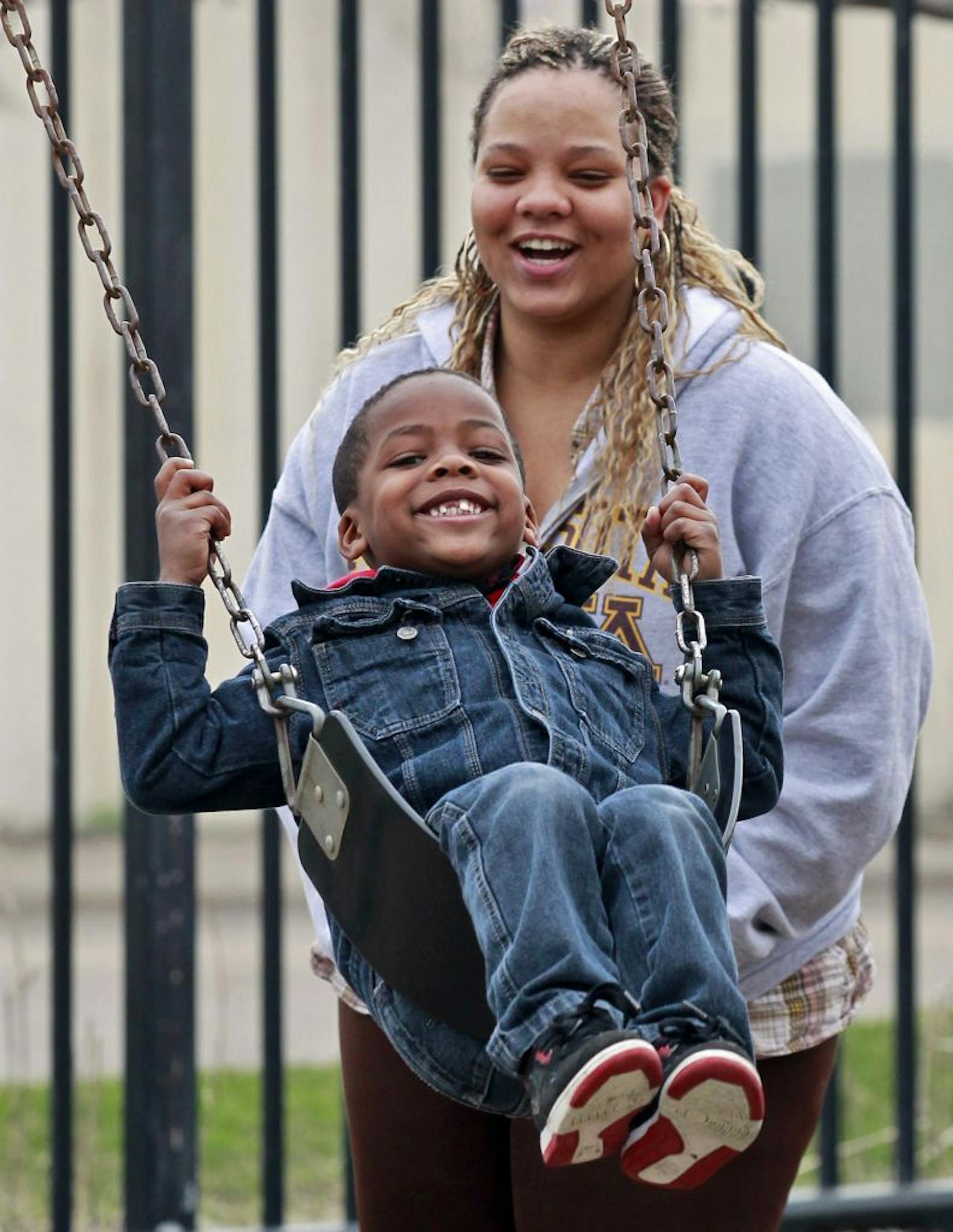Nekey Oliver and her son Giovanni on the swings.