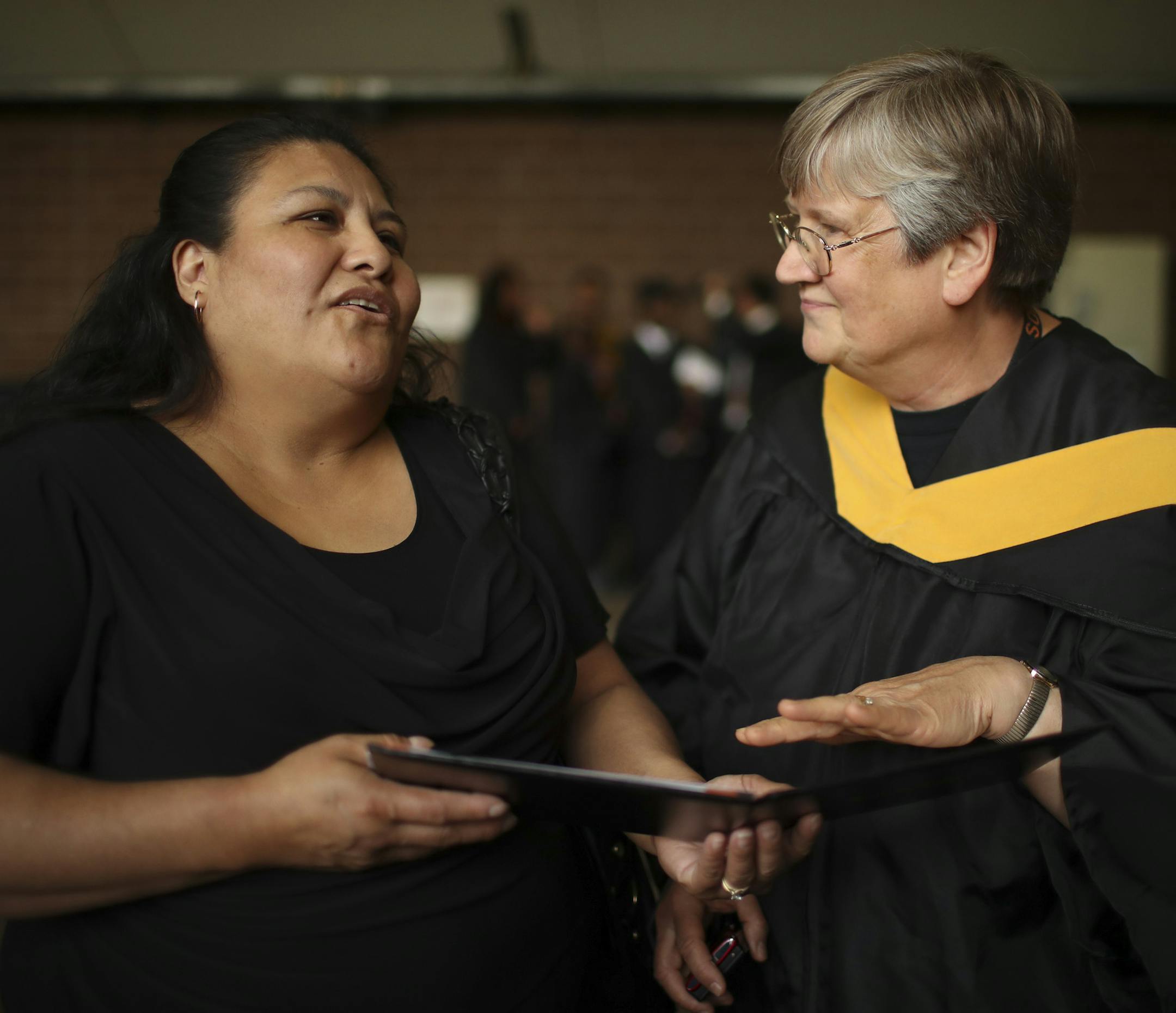 Guadalupe Galeno-Hernandez' mom, Hilda Hernandez, left, listened as Betty Aldrich, a Special Education teacher at South High School, explained that the certificate in Guadalupe's diploma folder was not her official diploma. That would come after she has taken some post-high school transitional classes at South next year. Guadalupe has met all the requirements for graduation; many special ed students choose to continue with more schooling before transitioning to community college or elsewhere. ]