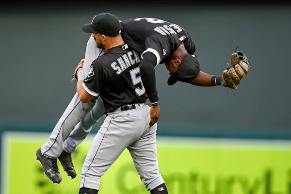 Chicago White Sox second baseman Carlos Sanchez carries off shortstop Tim Anderson after their defeat of the Minnesota Twins in 12 innings at a baseba
