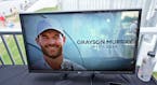 A golf television broadcast is played at the broadcast tent showing a photo of Grayson Murray during the third round of the Charles Schwab Challenge g