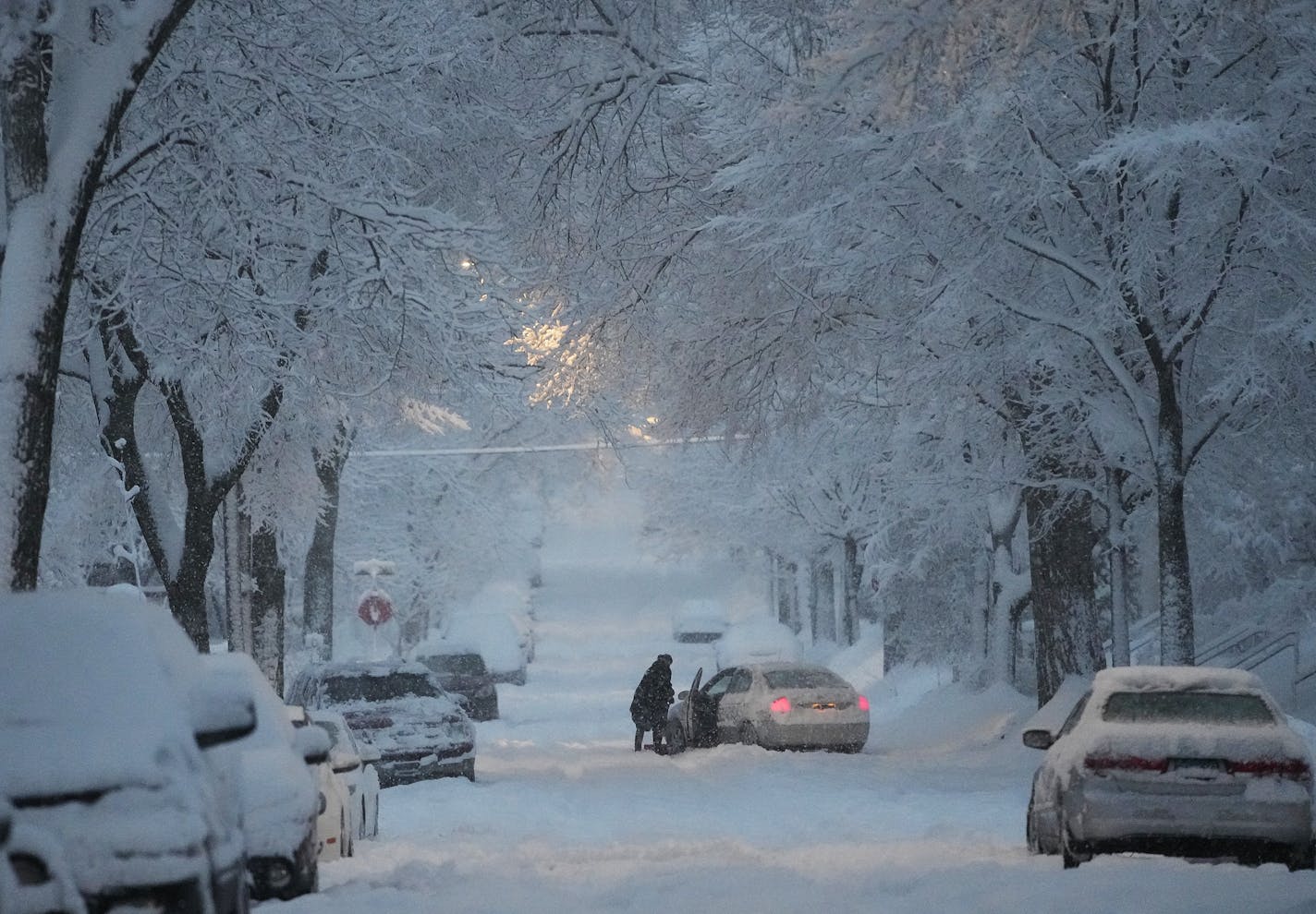 A motorist tries to dig out a stuck car on a south Minneapolis street Wednesday, Jan. 4, 2023 in Minneapolis, Minn. ]